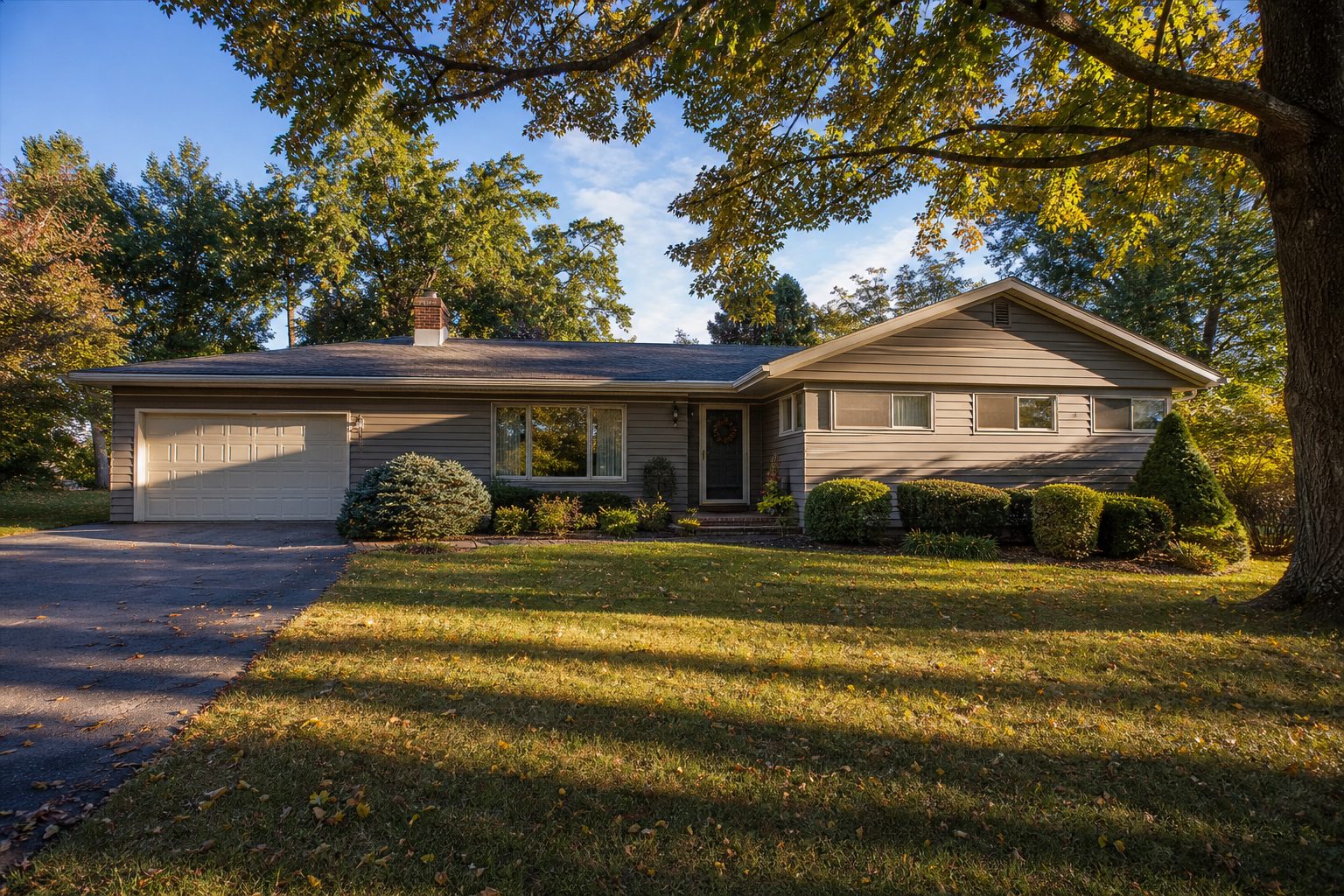Single-story ranch home with mature trees and manicured lawn in suburban Murrysville, Pennsylvania neighborhood.